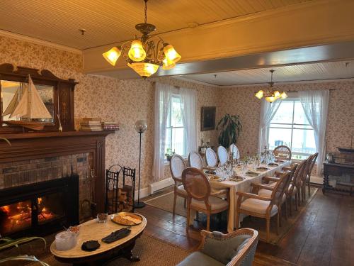 a dining room with a long table and a fireplace at Orcas Hotel in Orcas