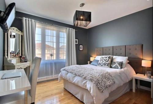 a bedroom with a large bed and a window at Lovely cottage with heated swimming pool in Quebec City