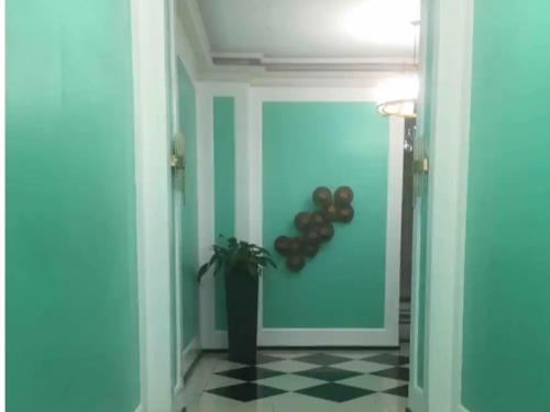 a hallway with a blue wall with a potted plant at CP19P TWINBED COZY ROOM Near at Venice Mall in Manila