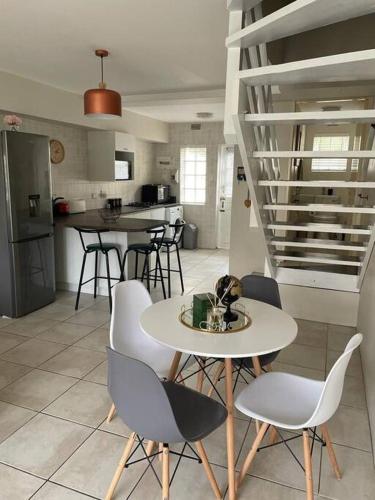 a kitchen with a table and chairs in a room at Arabella By The Sea in Port Alfred