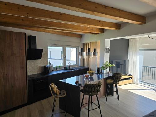 a kitchen with a black counter and chairs in a room at Panorama in Medulin
