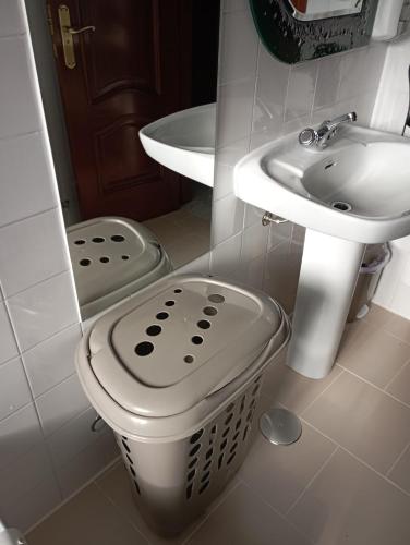 a bathroom with a sink and a waste basket at A Casa do San Paio de Buscás in Ordes