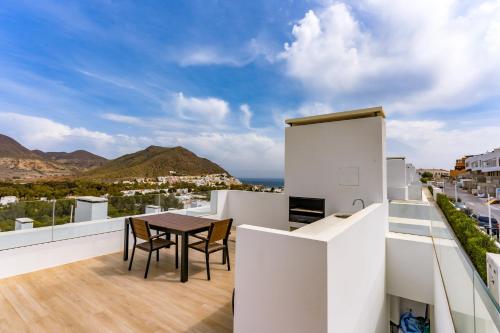 ein Balkon mit Tisch und Stühlen auf einem Gebäude in der Unterkunft San José Suites 3 Hab, Piscina, solárium y WiFi in Almería