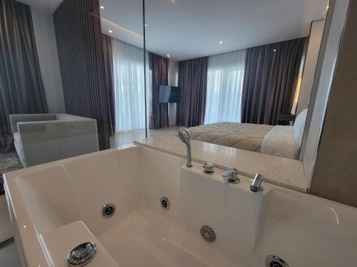 1 dormitorio con 1 cama y baño con bañera. en Hotel Enkelana en Pogradec