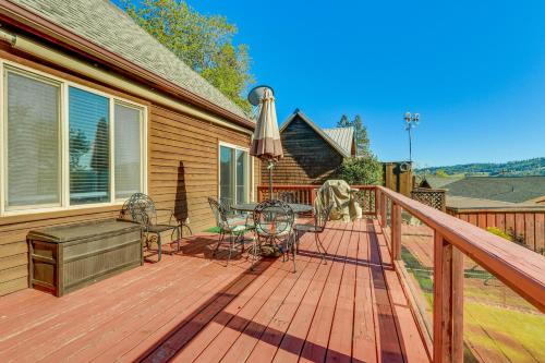 a wooden deck with a table and chairs and an umbrella at Harrison Home with Grill and Lake Views Walk to Town! in Harrison