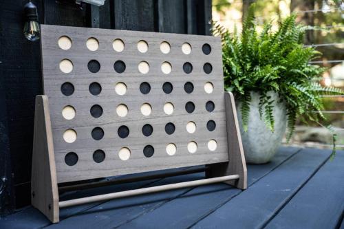 a wooden bench with drilled holes on it next to a plant at Pocono Mountain Retreat with Hot Tun and Sauna in Greentown