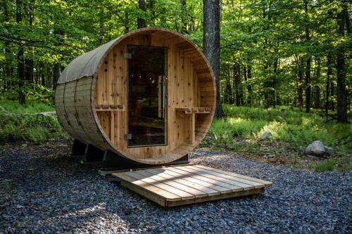 a wooden cabin in the middle of a forest at Pocono Mountain Retreat with Hot Tun and Sauna in Greentown
