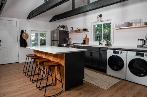 a kitchen with a sink and a counter with stools at Pocono Mountain Retreat with Hot Tun and Sauna in Greentown