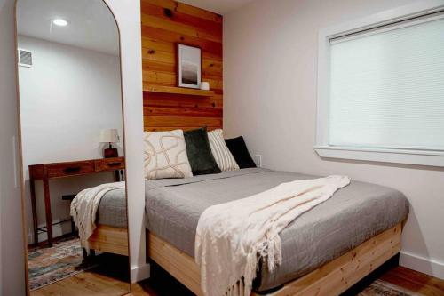 a bedroom with a bed with a mirror next to it at Pocono Mountain Retreat with Hot Tun and Sauna in Greentown