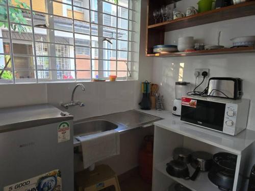 una cucina con lavello e microonde di Masons Tiny Cottage a Nairobi