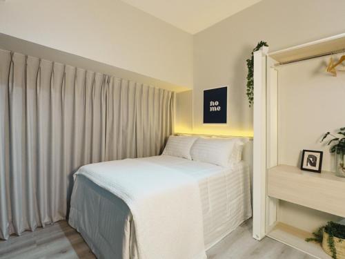 a small bedroom with a white bed and a window at Apê Metrô Higienópolis Mackenzie in Sao Paulo