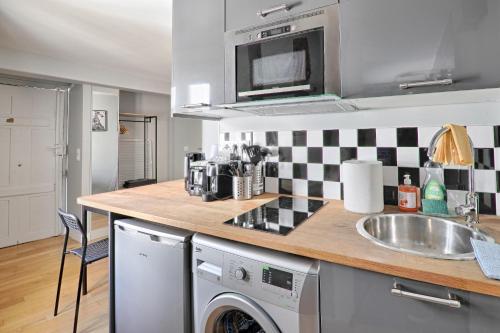 une cuisine avec un évier et une machine à laver dans l'établissement St André 4G - Best Location, à Paris