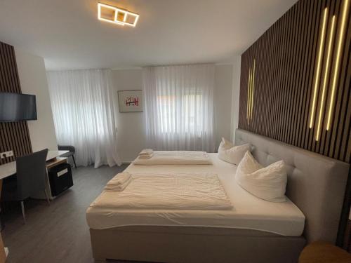 a hotel room with two beds and a desk at Hotel Loewen in Tübingen