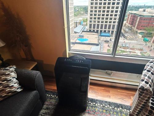 a room with a living room with a large window at 2 Full Beds, Rogers Place Downtown Central, Memorable 1 Bedroom Condo in Edmonton