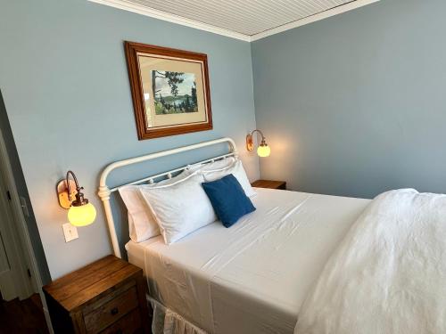 a bedroom with a white bed with two blue pillows at Orcas Hotel in Orcas