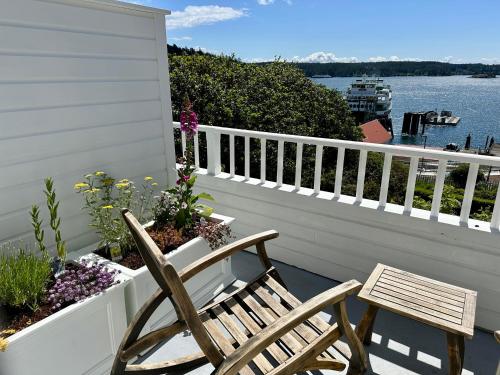 a patio with two chairs and flowers on a balcony at Orcas Hotel in Orcas