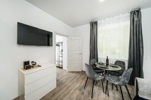 a living room with a table and chairs and a television at Riverra House in Kaunas