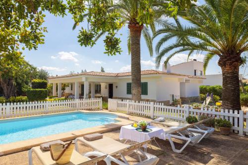 a villa with a swimming pool and palm trees at Ideal house for two families with pool and barbecue in Palmanyola