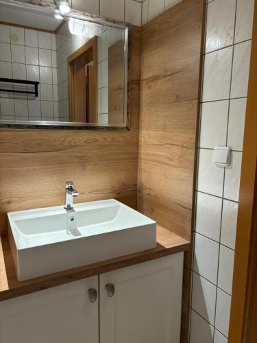 ein Badezimmer mit einem weißen Waschbecken und einem Spiegel in der Unterkunft Strandstern Norddeich in Norddeich