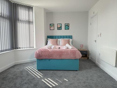 a bedroom with a bed with a pink blanket at Relax @ Southfield in Middlesbrough