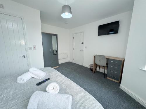 a bedroom with a bed and a desk and a television at Relax @ Southfield in Middlesbrough