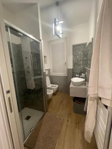 uma casa de banho com um chuveiro, um WC e um lavatório. em La Casa di Satèn - Appartamento in Franciacorta em Erbusco