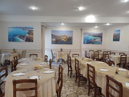 sala bankietowa ze stołami i krzesłami z białymi obrusami w obiekcie Hotel Monna Lisa w mieście Procchio