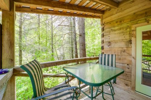 a table and chairs on the deck of a cabin at Near Lake Lure Quiet Cabin with Deck and Trail Access in Marion