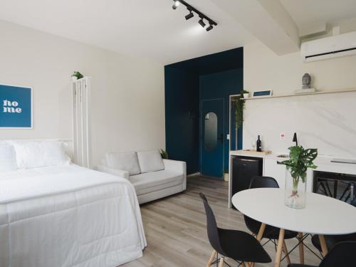 a bedroom with a bed and a table and chairs at Apê Metrô Higienópolis Mackenzie in Sao Paulo