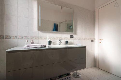 ein Bad mit einem Waschbecken und einem Spiegel in der Unterkunft Giuseppe's House in Monserrato