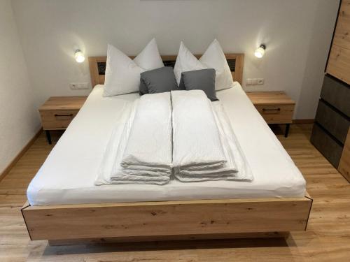 a large bed with white sheets and pillows on it at Ferienwohnung Kirschner in Unter Tösens inkl SUPER SOMMER CARD in Serfaus