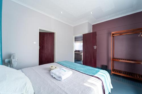 a bedroom with a bed with a teddy bear on it at KhayaLethu Vic Falls 2 in Victoria Falls