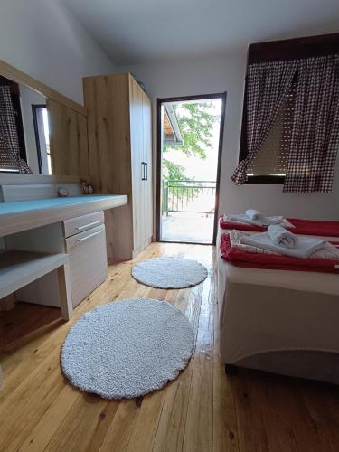a room with two rugs on the floor and a kitchen at WIN apartment in Pluzine