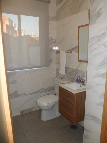 a white bathroom with a toilet and a sink at Guest house D. Filipe I in Porto