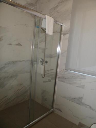 a shower with a glass door in a bathroom at Guest house D. Filipe I in Porto