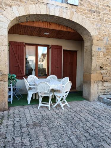 une table et des chaises assises sur une terrasse dans l'établissement Gite du soleil levant jura, à Gevingey
