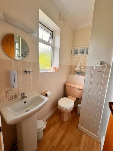 a bathroom with a sink and a toilet at High Trees Guest House Gatwick in Horley