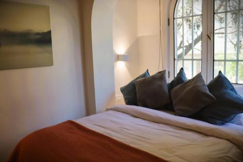 a bedroom with a bed with pillows and a window at HOM I Departamento 2PAX AlA Barrio Lastarria in Santiago