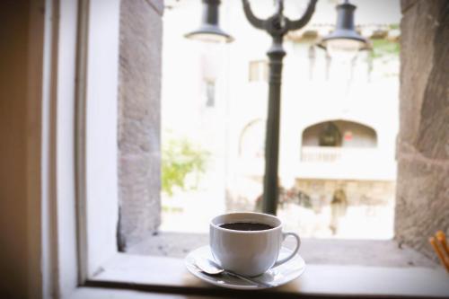a cup of coffee sitting on a table next to a window at HOM I Departamento 2PAX AlA Barrio Lastarria in Santiago