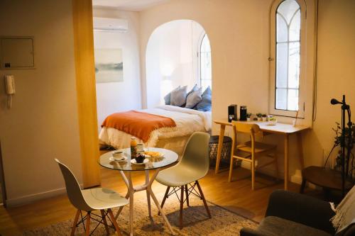 a bedroom with a bed and a table and chairs at HOM I Departamento 2PAX AlA Barrio Lastarria in Santiago