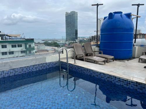 巴拿馬城的住宿－Hotel HSR，一个带两把椅子的游泳池,一个蓝色的大桶