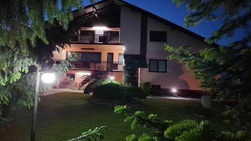 a large building with lights in a yard at night at Apartman Katarina in Čakovec