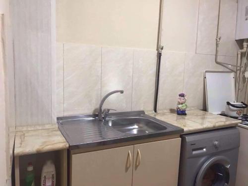 uma cozinha com um lavatório e uma máquina de lavar roupa em Anahit's Apartment em Vagharshapat
