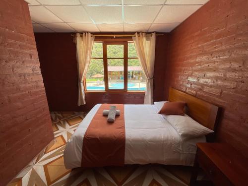 1 dormitorio con 1 cama grande y ventana en Playita Salomon, en Baños