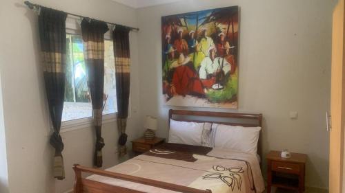 1 dormitorio con 1 cama y una pintura en la pared en résidence golfique, en Fez