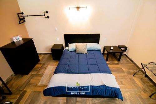 um quarto com uma cama com um edredão azul em A02 Full Suite ‖ Mini Dept at Plaza Acequia em Cuautitlán Izcalli
