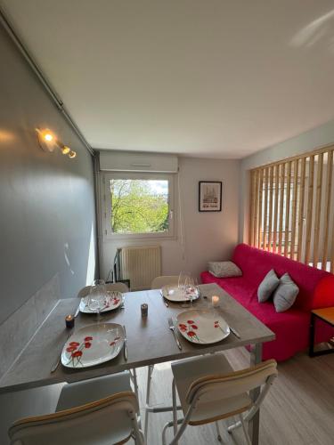 - un salon avec une table, des chaises et un canapé rouge dans l'établissement Vauban T1 calme avec parking privatif, à Lille