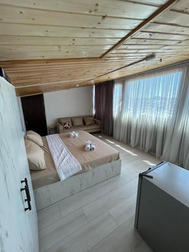 a bedroom with a large bed and a wooden ceiling at Tskhumi Apartment in Kutaisi