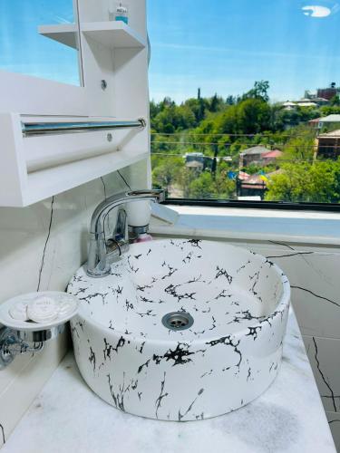 a bathroom with a sink and a window at Tskhumi Apartment in Kutaisi
