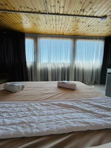 a large bed in a room with a window at Tskhumi Apartment in Kutaisi